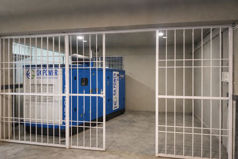 The building's diesel generator installation behind its grille