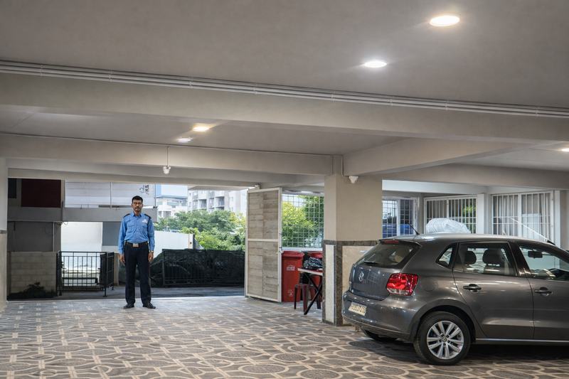 The same parking floor from the far end, the guard on duty and the length of the covered bays