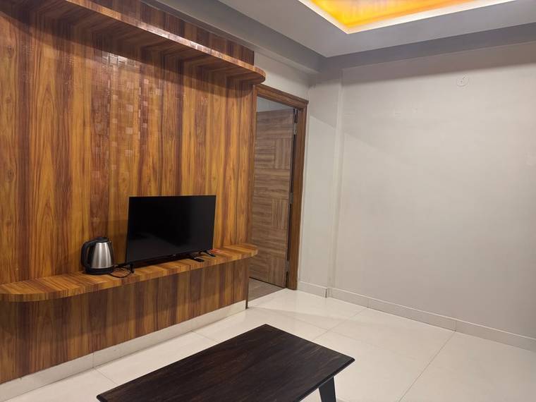 A lit apartment interior — cove lighting on and the television running