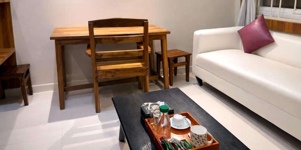A furnished living area with a sofa, a dining table and a tea tray laid out