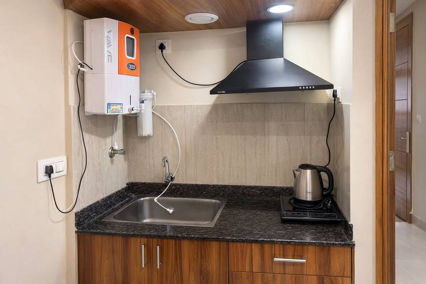 The kitchenette counter with hob, sink, chimney and water heater