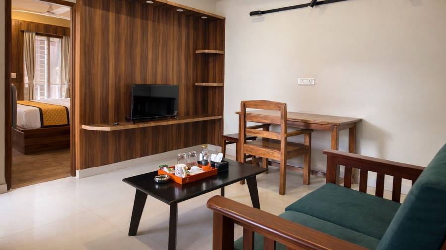 A Super Deluxe 1BHK — the hall, with the bedroom and its balcony through the doorway